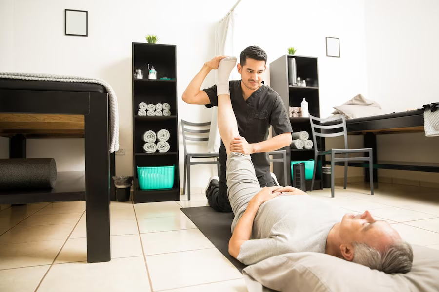 medico-fisioterapia-que-ayuda-paciente-anciano-ejercicio-piernas-clinica_662251-1742